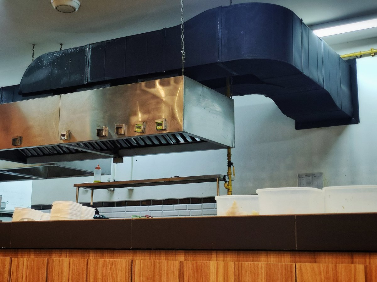 Stainless steel exhaust hood above a commercial range