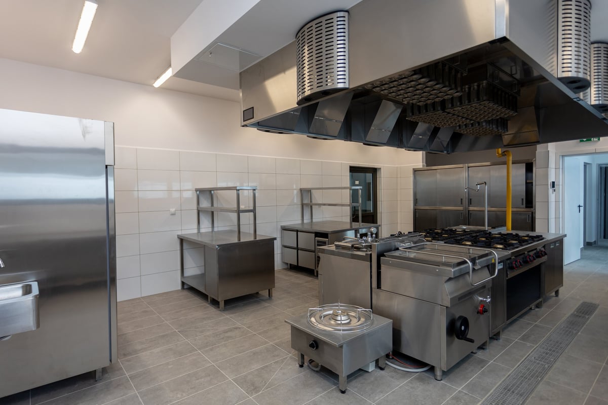 Spacious commercial kitchen with stainless steel appliances and professional cooking equipment