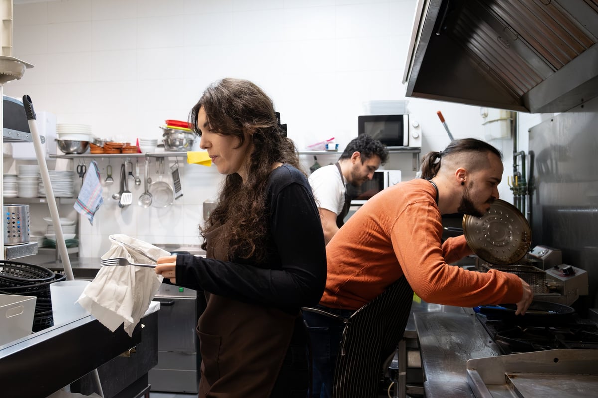 Restaurant staff collaborating in a professional kitchen preparing dishes