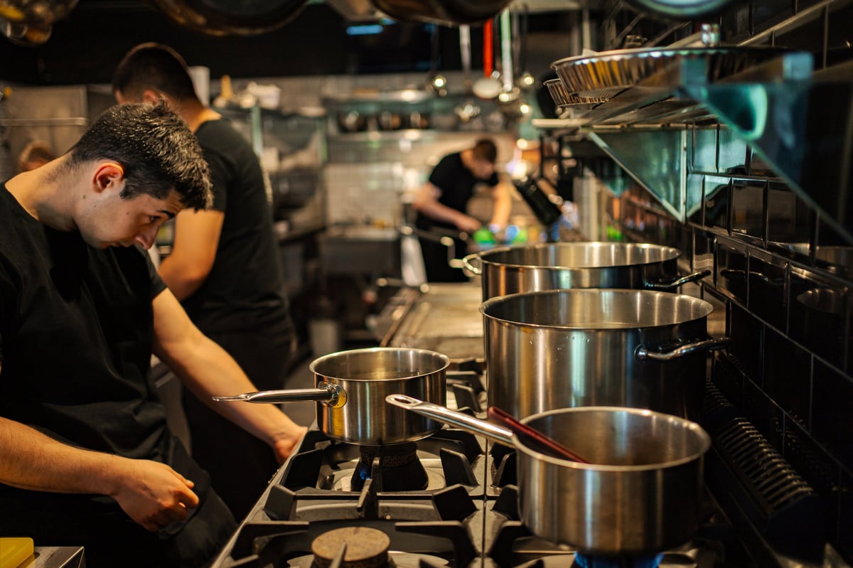 Restaurant chefs preparing food on the stoves in a professional kitchen